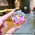 Dettaglio del ciondolo a fragola con dimensioni 4,6cm x 5,2cm e perle colorate interne - Senza fibbia / Iridescente