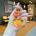 Detailed view of orange heart keychain with glitter, wings, and a small red bell - Lobster Clasp Style / Orange