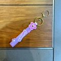 Detail of pink Sakura silicone wristlet strap with golden metal keychain and clasp - Purple