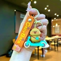 Detail of Capybara keychain riding a green scooter with orange Luck wrist strap - Capybara Green Skateboard