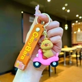 Detail of Capybara on pink scooter keychain with orange luck wristlet and golden clasp - Capybara Pink Scooter