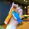 Detail of Capybara keychain with blue shark, orange silicone strap and gold metal ring - Capybara Blue Shark