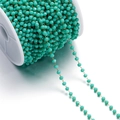 Detail of mint green faceted glass beads on a gold chain wound on a white spool - 1 Meter/Pack (Approx. 3x3.5mm) Approx. 10g / Gold Green