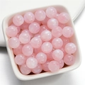 Primo piano di perle in resina a sirena rosa con glitter cangianti in un piatto di ceramica - Rosa