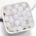 Dettaglio macro di perle in resina bianco perlato con finitura brillante in un piatto - Bianco