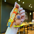 Cute brown silicone Capybara keychain on a yellow skateboard with orange hand strap - Driving Capybara Yellow Skateboard
