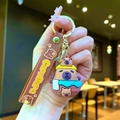 Simpatico portachiavi Capybara con figure e cinturino in silicone marrone per borse - Capibara che fa il Bagno Tenendo in Alto