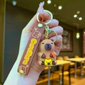 Silicone capybara keychain with brown strap and golden metal ring held by a hand - Bathing Capybara Chanting