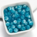 Macro shot of 8mm lake blue cat eye resin beads with center hole in a white ceramic bowl - 8mm / Blue