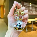 Detalle del llavero de panda con estrellas doradas en una funda de resina de conejo - Orejas de Conejo / Herraje Dorado Conejo con Auriculares Panda Biberón Negro Oro