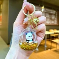 Primer plano de llavero panda con arenas movedizas, lentejuelas doradas y cascabel - Forma Bolsa Espacial / Herraje Dorado Bolsa Espacial Panda Biberón Negro Oro