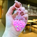 Detailansicht vom rosa Erdbeeren Schlüsselanhänger mit Glitzerfüllung und Glöckchen - Rosa