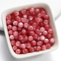 Pink resin cat eye round beads in a white ceramic bowl for DIY jewelry making - 6mm / Deep Pink