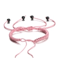 Detail van roze gevlochten armband met verstelbare zwarte kralen op een witte achtergrond - 1 Stuk Ongeveer 5.5g / Oudroze
