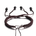 Macro-opname van donkerbruine gevlochten armband met schuifknoop en zwarte kralen - 1 Stuk Ongeveer 5.5g / koffiekleur