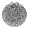 Close-up of translucent grey-blue glass apple beads in a decorative tray for DIY jewelry - Gray