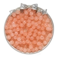Macro detail of glossy pink glass apple beads on a silver tray for DIY jewelry - Orange