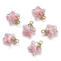 Detail view of six star-shaped glass pendants with pink glitter and gold metal rings - 5 Pieces / Pink