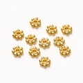 Close-up of 6mm golden snowflake spacer beads for DIY jewelry making and necklaces - 50 Pieces / Gold