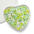 Close-up of 4mm colorful acrylic peanut beads in a heart-shaped ceramic dish for DIY - 100 Units (3x4x6.5mm) / Transparent Green Mix