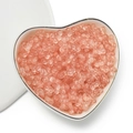 Close-up of 4mm peach acrylic peanut beads for DIY jewelry making in a heart-shaped plate - Matte Orange