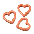 Detail von herzförmigen Karabinern in Orange mit rosa Punkten für DIY-Schmuck - Orange