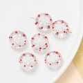 Détails macro de perles de Noël transparentes avec flocons blancs et motifs à pois rouges - Flocon de neige