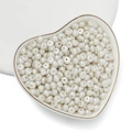 Dettaglio macro di perle in acrilico bianco crema a goccia in un vassoio di cuore - 100 Pezzi/Confezione / Perla Artificiale - Bianco