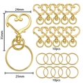 Dettaglio di moschettoni a cuore dorati e anelli portachiavi con misure 24x35mm - 10 Chiusure E 10 Anelli / Oro