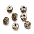 Macro view of vintage tibetan silver beads with gold plating and skull pattern relief - 1pc/pack / Style 14 (Lotus Cap Barrel)