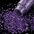 Nahaufnahme von violetten Glassteinen, die aus einer Flasche auf schwarzen Spiegel fallen - 30ml Flasche / Blau und Violett
