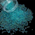 Macro of iridescent teal glass beads pouring from a container for DIY resin and nail art - 28g per Box / Lake Blue