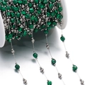 Close-up of DIY jewelry chain with green faceted stones and silver beads on white spool - Steel Style 08
