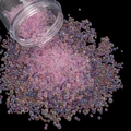 Close-up of pink iridescent glass micro beads spilling onto a black background for nail art - 28g per Box / Deep Pink