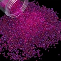Macro view of magenta glass micro beads pouring out for nail art and DIY resin crafts - 28g per Box / Rose Red