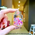 Gros plan détaillé d'un mini bocal en acrylique avec perles colorées et breloques fleurs - Forme de réservoir de gaz