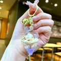 Macro detail of acrylic seashell keychain with real shells and purple glitter inside - Conch Pendant (Gold Buckle) / Purple