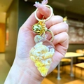 Detail of seashell keychain with glitter, small shells inside, and a pink ribbon charm - Conch Pendant (Gold Buckle) / Yellow