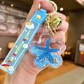 Starfish liquid sand keychain with ocean blue silicone strap and golden bell charm - Color Cloud Strap Blue Starfish Flower
