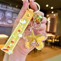 Yellow shell keychain with floating starfish, sand details and gold bell accessory - Color Cloud Strap Yellow Starfish Flower