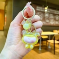 Mini acrylic charm keychain featuring a cute yellow doll and a sparkling glitter ball - Yellow