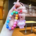 Primo piano di un portachiavi colorato con perline, figura viola e perline macaron - Charm Cartoon con Perline Arcobaleno / Rosa