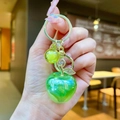 Detailed view of green apple keychain with gold leaf charm and clear resin texture - Gold Hardware Electroplated Apple / Aurora Green