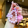 Detalle de llavero de cuentas rosas con bola de purpurina y lazo decorativo color lila - 1 pieza / Piruleta Luminosa Rosa