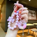 Nahaufnahme der rosa Perlenkette mit Donut-Anhänger und Schleifen-Accessoire - Rosa Leuchtend Donut