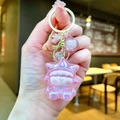 Detailed view of pink pearlescent star doll keychain with bow and gold star clip - Gold Hardware Electroplated Star Person / Aurora Pink