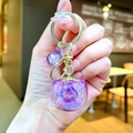 Detailed view of a purple resin apple keychain with gold ring and matching beads - Gold Hardware Purple Electroplated Persimmon
