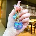 Detail of a large gradient blue glass apple keychain charm with golden hardware - Gold Hardware Blue Electroplated Persimmon