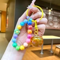Detailed shot of beaded persimmon keychain with orange apple pendant and colorful letters - Multicolor Beaded (Yellow)