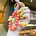 Detailed shot of handmade colorful beaded keychain with orange beads and heart pendant - Orange Milky Bean Heart